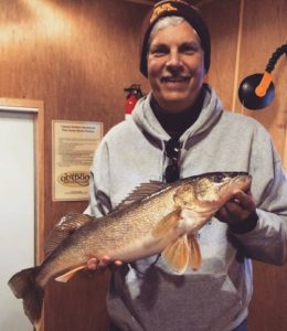 Happy fisherman with a nice walleye in one of our fish houses.