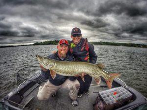 Josh and Dierks Opatz with a great muskie under a cloudy sky.